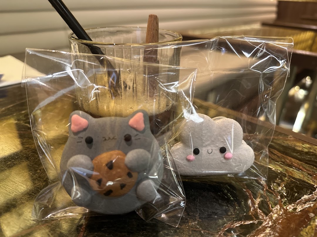 Adorable cat and cloud-shaped treats alongside a refreshing drink, showcasing Sugarsmith's delightful creations.