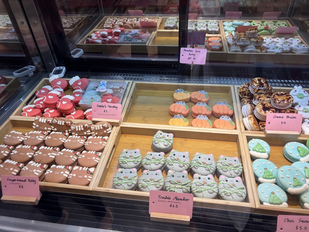 A vibrant display of character-themed macarons and desserts in a glass case at Sugarsmith.
