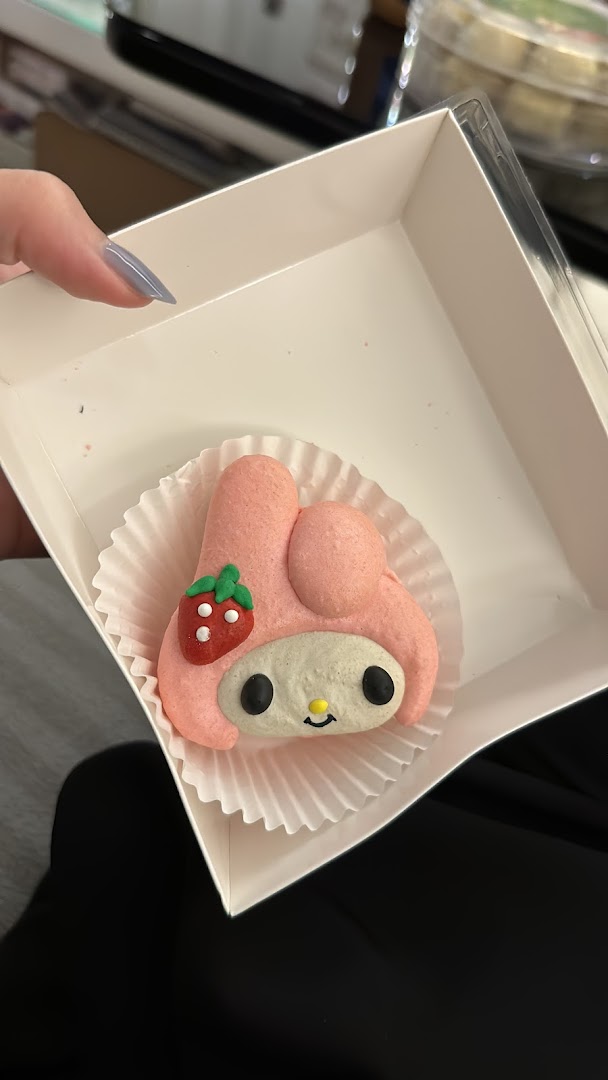 A pink My Melody character macaron with a strawberry design in a white box.