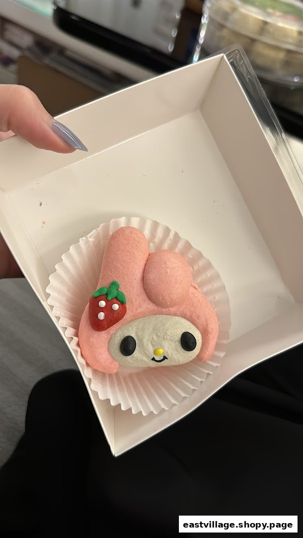 A pink My Melody character macaron with a strawberry design in a white box.