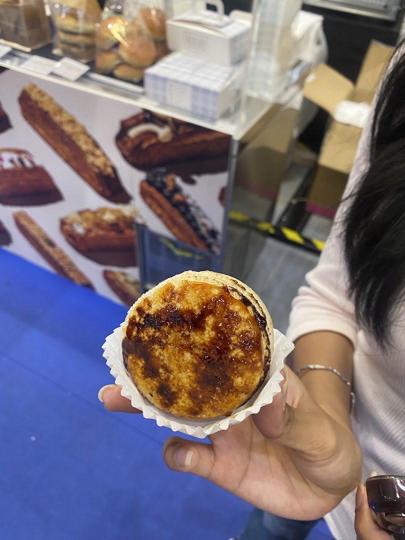 A hand holds a delicious-looking dessert with a caramelized top, likely from Sugarsmith.