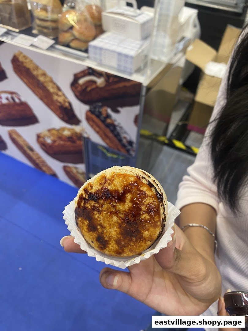 A hand holds a delicious-looking dessert with a caramelized top, likely from Sugarsmith.