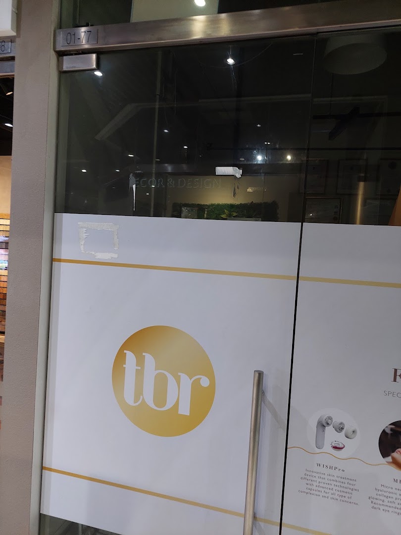 The glass entrance of The Beauty Room (tbr) featuring its logo and details about skin treatments.