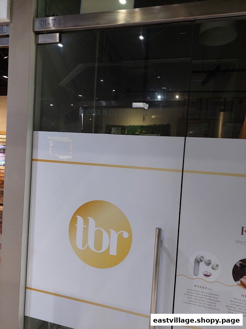 The glass entrance of The Beauty Room (tbr) featuring its logo and details about skin treatments.