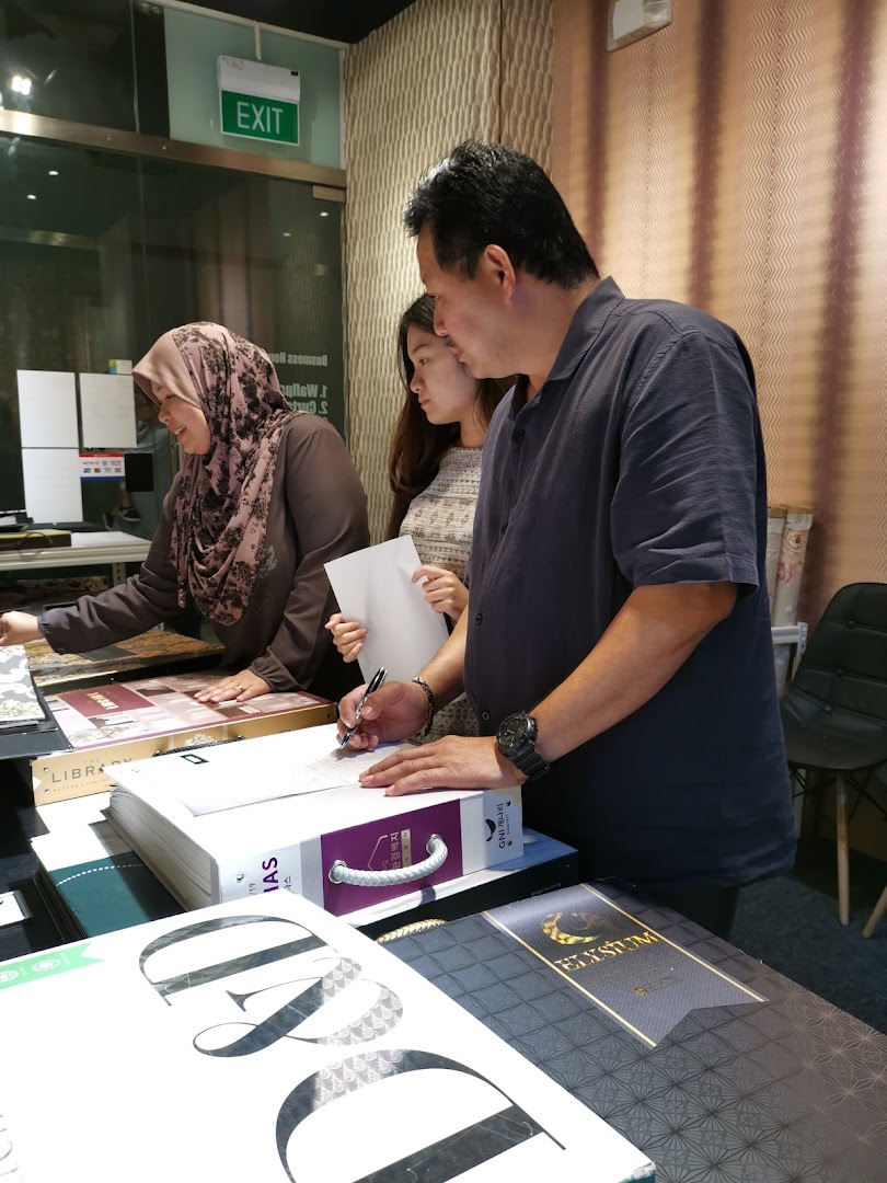 Customers and staff reviewing wallpaper and curtain samples in a design gallery.