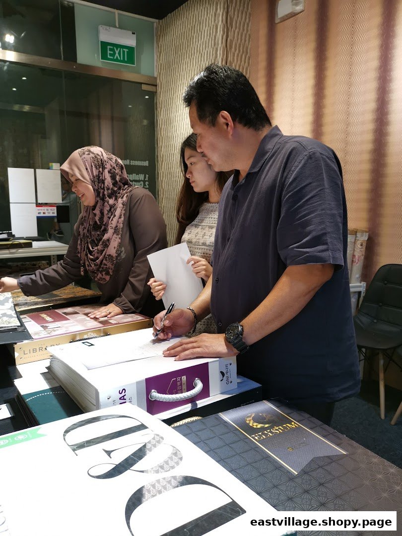 Customers and staff reviewing wallpaper and curtain samples in a design gallery.