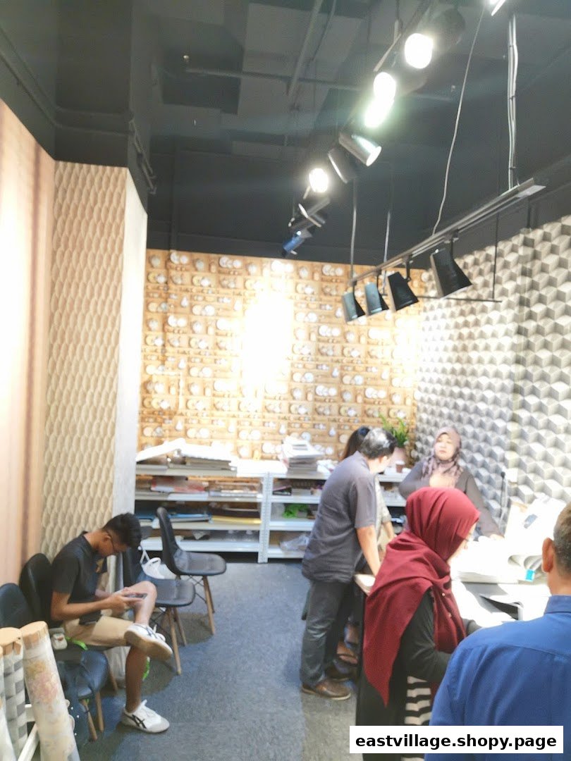 Customers and staff interact within The Catalogue Wallpaper Curtains Gallery, showcasing design options.