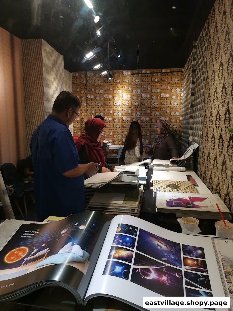 Customers and staff browse wallpaper and curtain design catalogs inside The Catalogue Gallery.