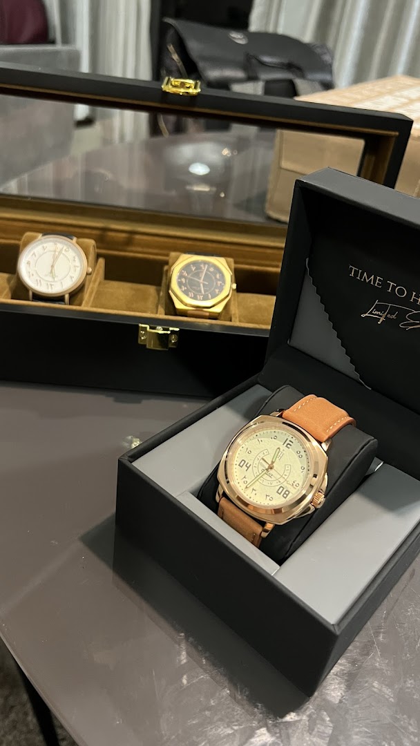 A collection of elegant watches, including one in an open box, displayed in a retail setting.