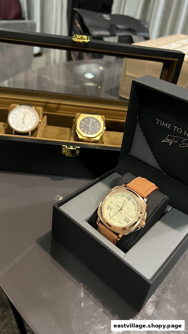A collection of elegant watches, including one in an open box, displayed in a retail setting.