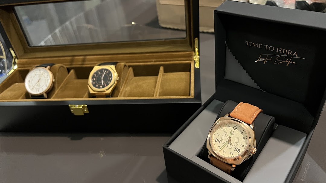 A collection of elegant watches displayed in a watch box and an open gift box.