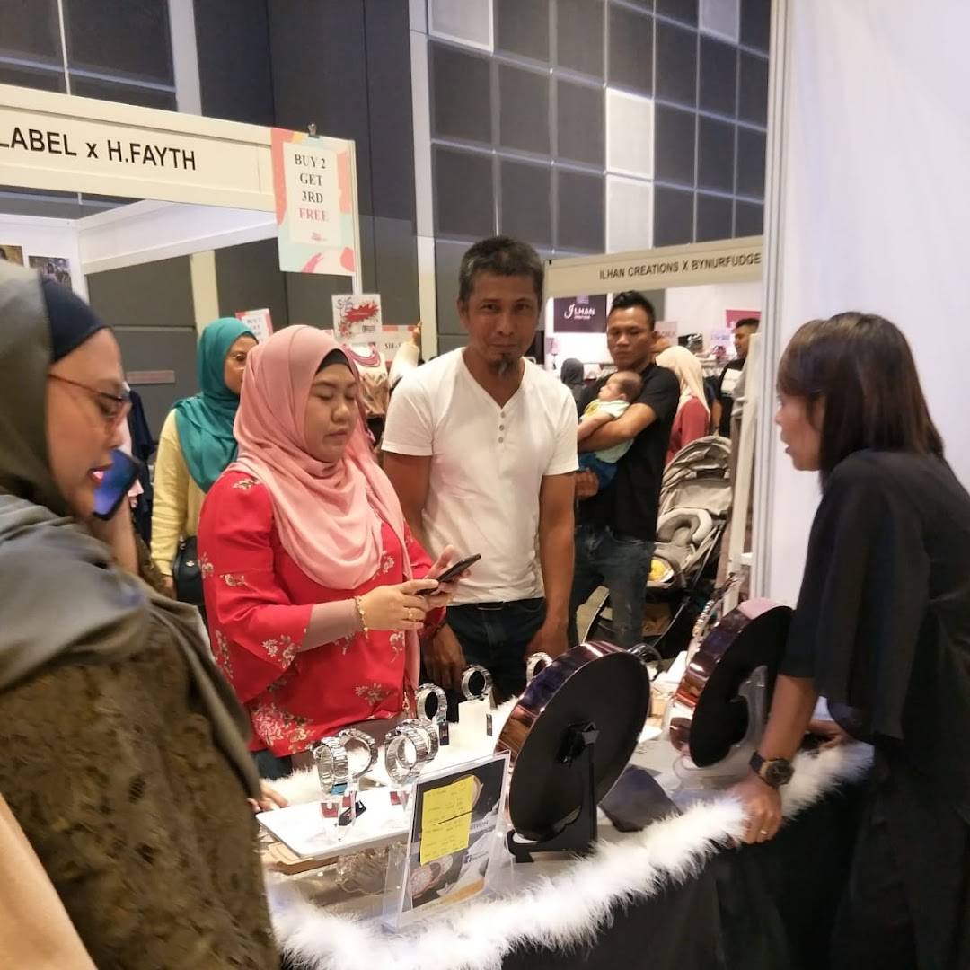 Customers browse products at a lively retail booth, engaging with staff and exploring items on display.