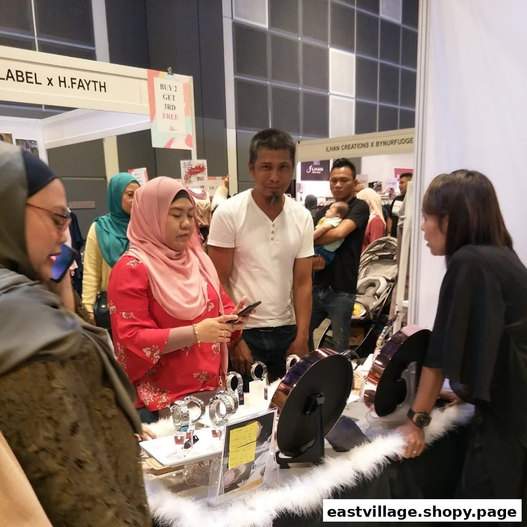 Customers browse products at a lively retail booth, engaging with staff and exploring items on display.