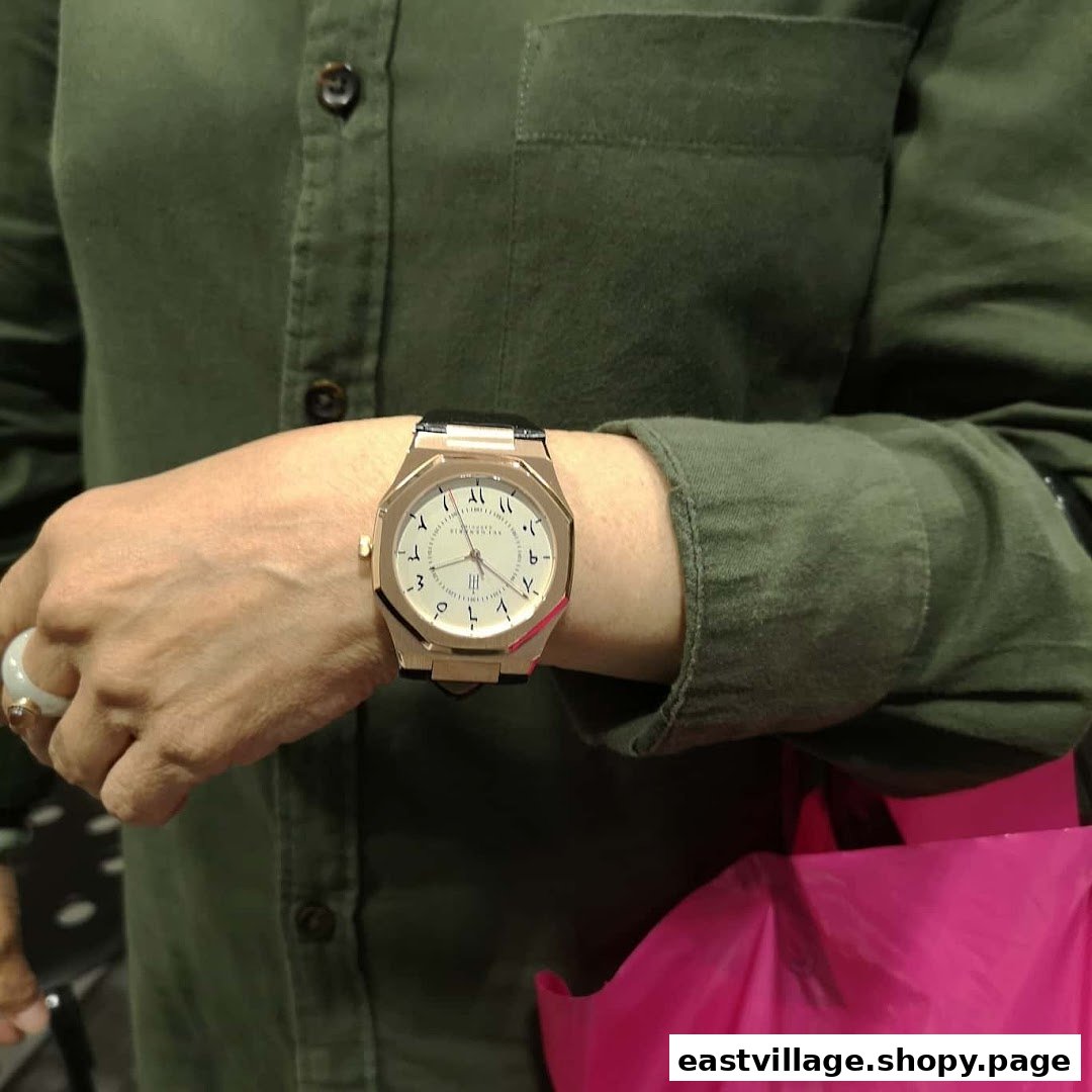 A person wearing a stylish watch with Arabic numerals, showcasing the unique design of the timepiece.