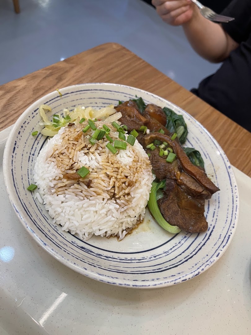 A plate of braised meat with rice and vegetables, garnished with spring onions, from 張餘記.