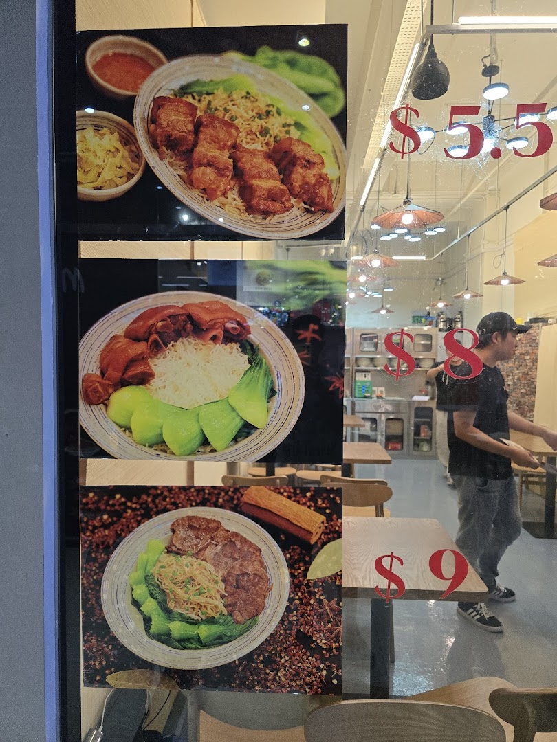 Close-up of a shop window displaying three popular food dishes with their prices.