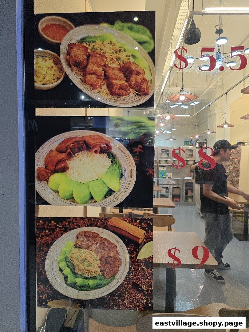 Close-up of a shop window displaying three popular food dishes with their prices.