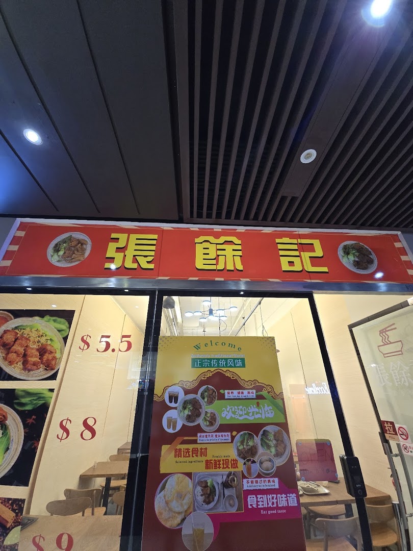 The shopfront of '張餘記' featuring its red signboard, window displays with food images, and prices.