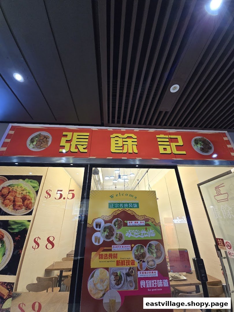 The shopfront of '張餘記' featuring its red signboard, window displays with food images, and prices.