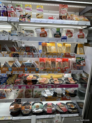 A refrigerated display case in a 7-Eleven store filled with food items.