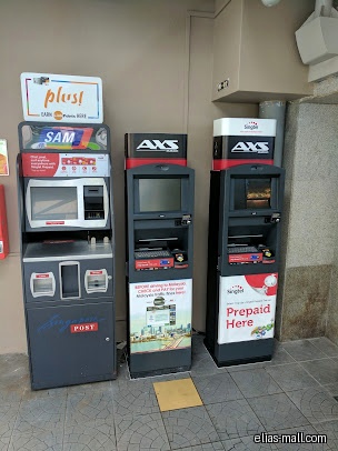 The image shows three service kiosks: SAM, AXS, and Singtel.