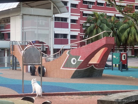 The image shows a playground with a boat-shaped structure and other play equipment.