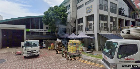 Elias 1 Station Market shop front with trucks and goods outside.