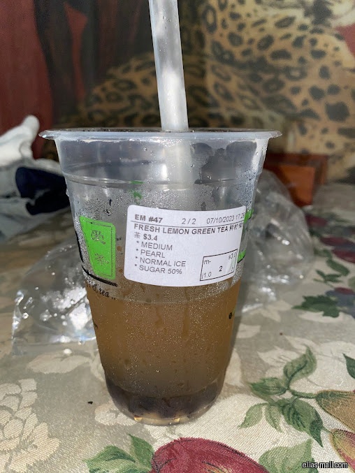 A cup of iTEA Fresh Lemon Green Tea with pearls and a straw.
