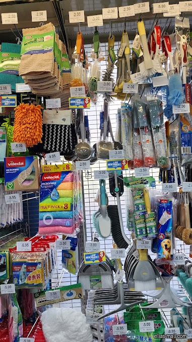A display of cleaning supplies, including brushes, mops, and cloths, in a store.