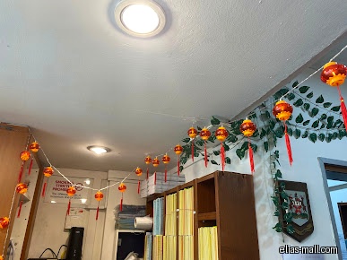 The image shows the interior of Oei Family Clinic with Chinese New Year decorations.