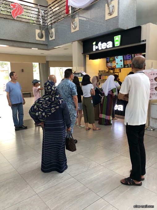 People are waiting in line at the i-tea shop in a mall.