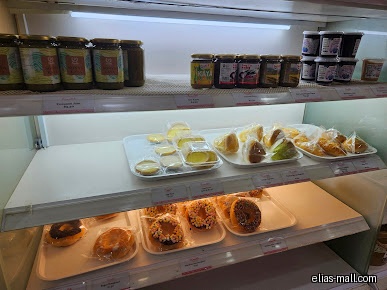 PrimaDéli display case with jars of jam and trays of pastries.