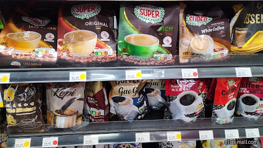 Shelves stocked with various brands and flavors of instant coffee mixes.