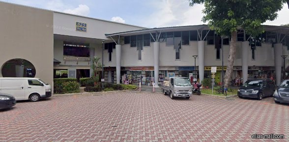 The image shows the exterior of a commercial building with several shops.