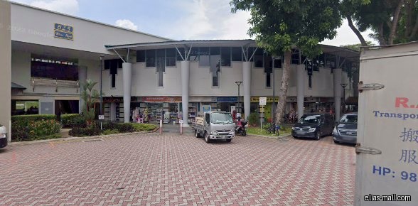 The image shows the exterior of a building with several shops.