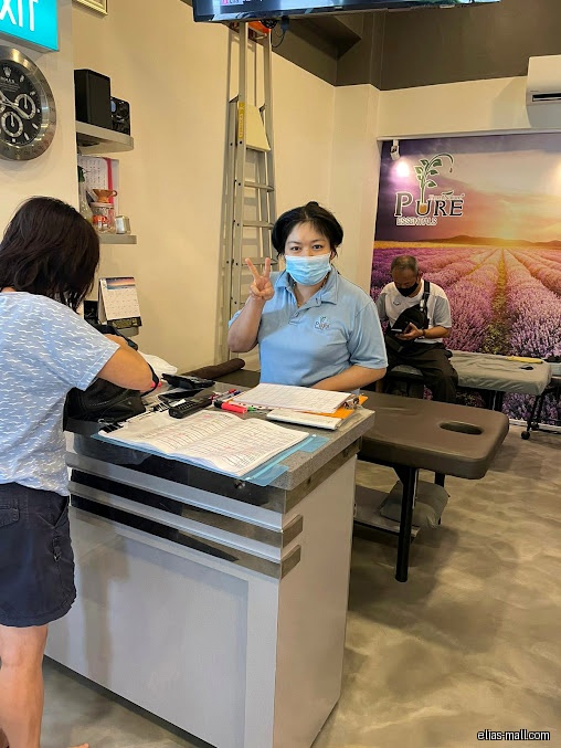 Inside Wil Essentials, a staff member poses at the counter with a customer.