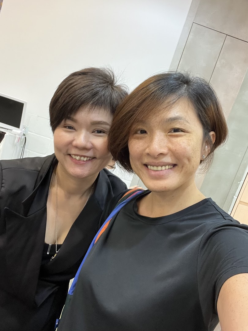 Two smiling women, likely staff or customers, posing for a photo inside 1Gravity Funan.