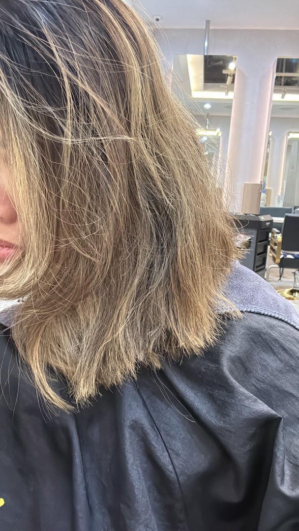Close-up of a person's styled hair, showcasing a fresh look from the salon.
