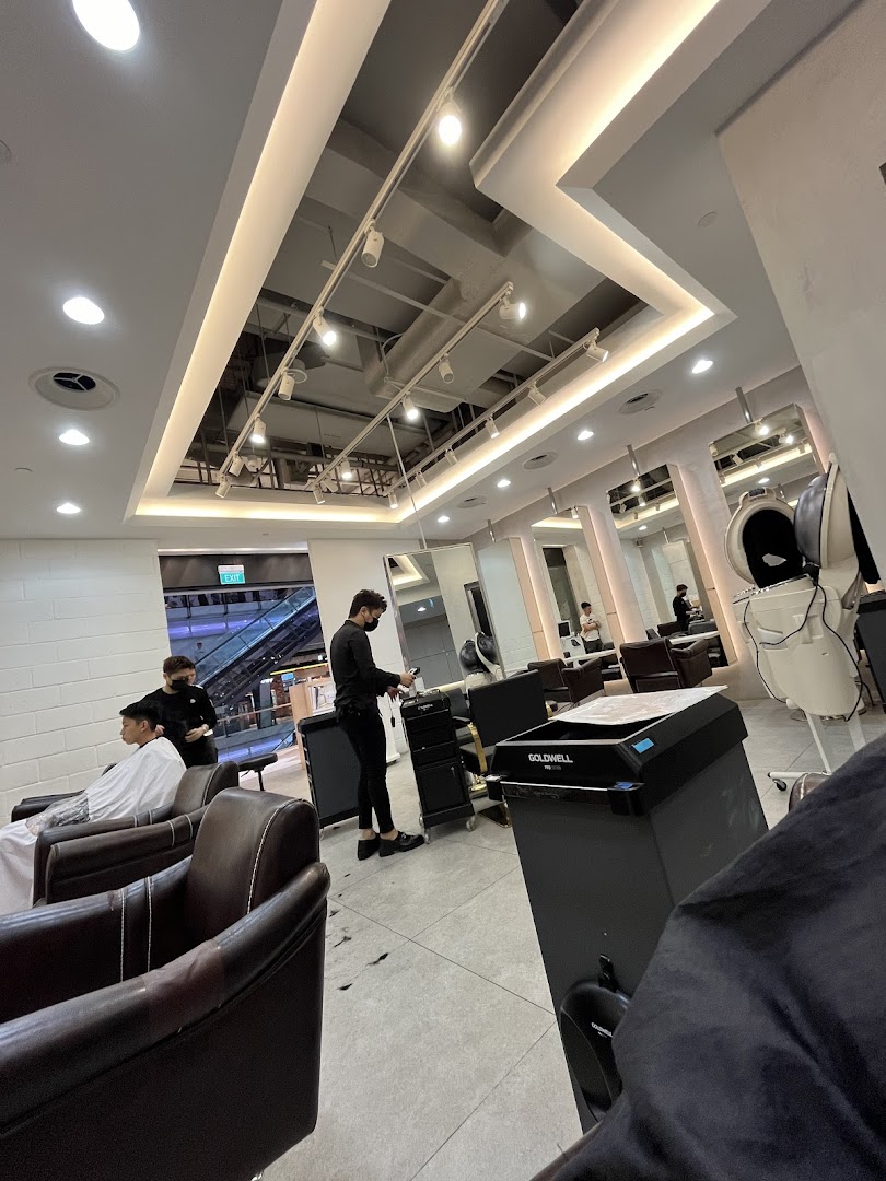 Interior view of a modern hair salon with stylists attending to customers.
