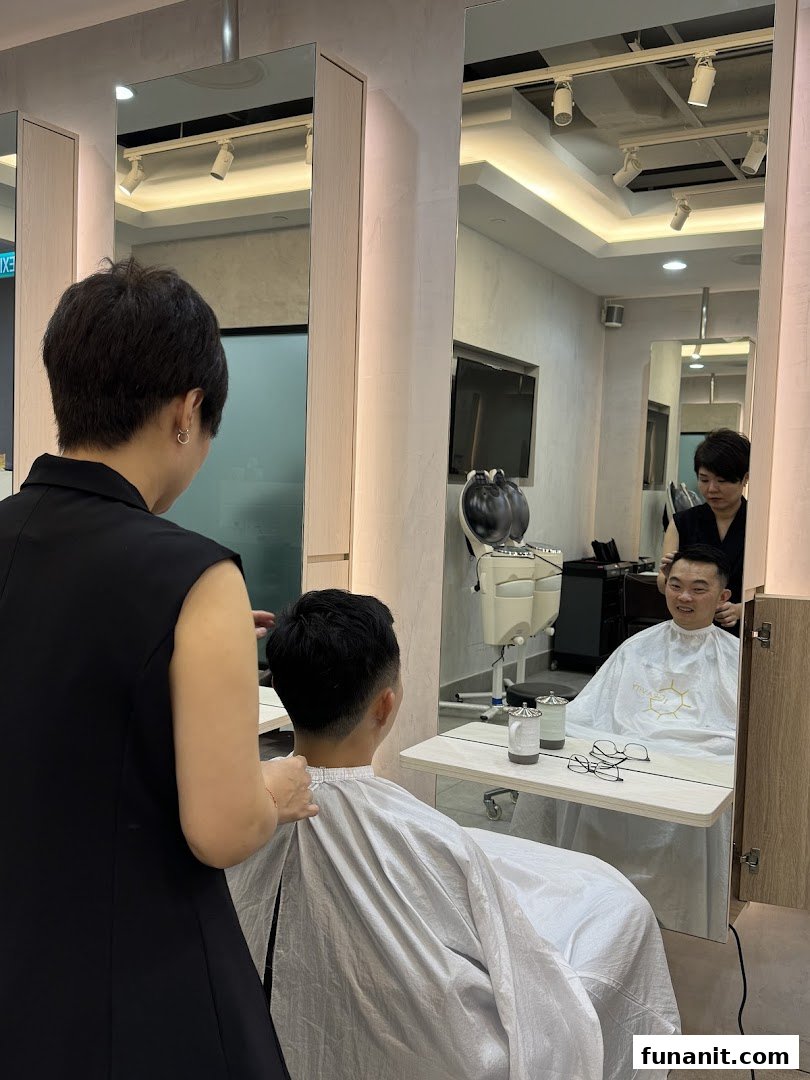 A stylist at 1Gravity Funan gives a customer a fresh haircut in a modern salon setting.