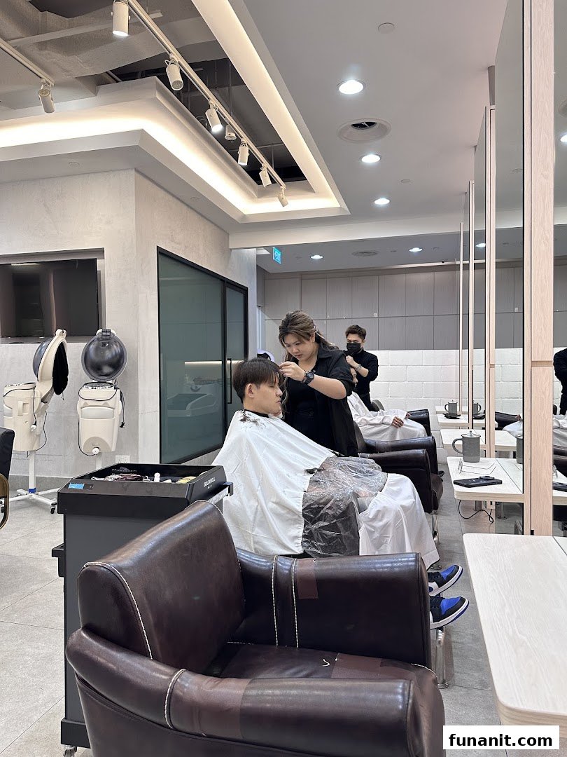 A customer receives a haircut from a stylist in a modern, well-lit hair salon.