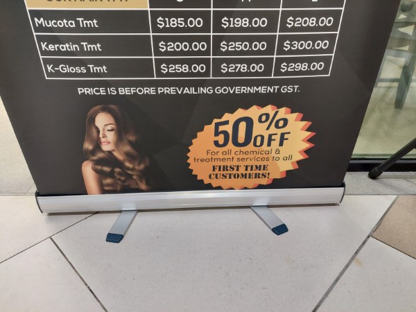 A banner displaying hair treatment services, prices, and a first-time customer discount offer.