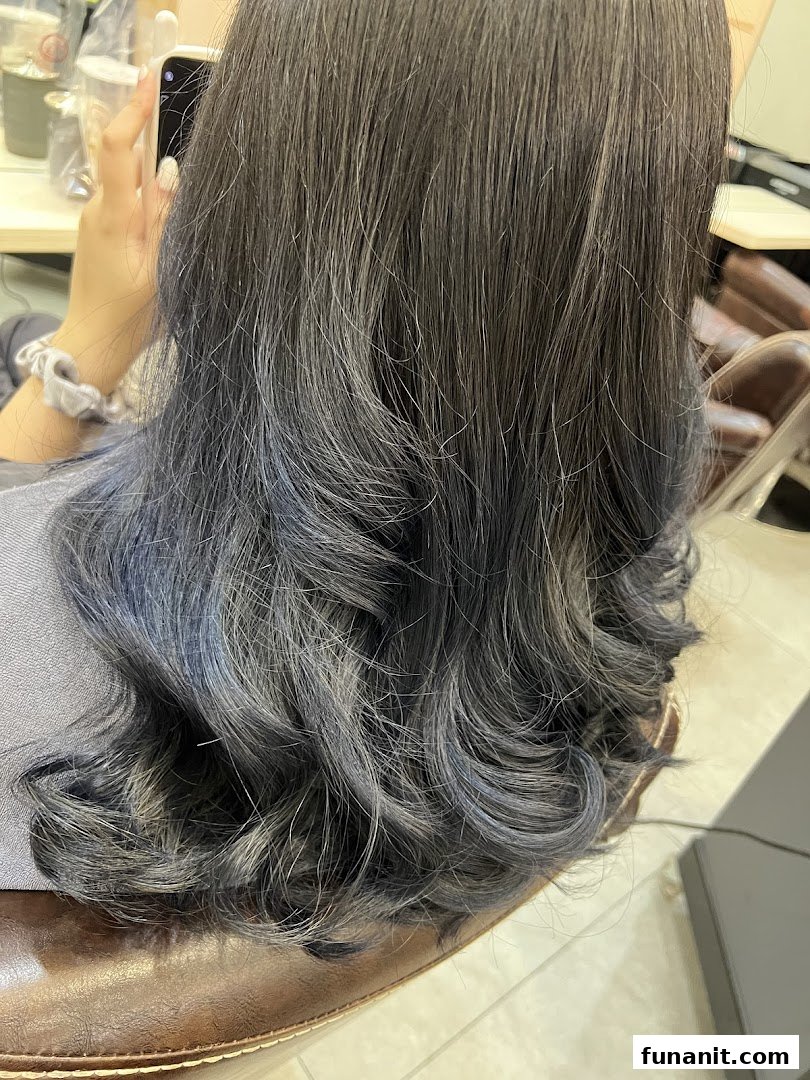Close-up of a person's styled hair with subtle blue highlights, showcasing hair treatment results.
