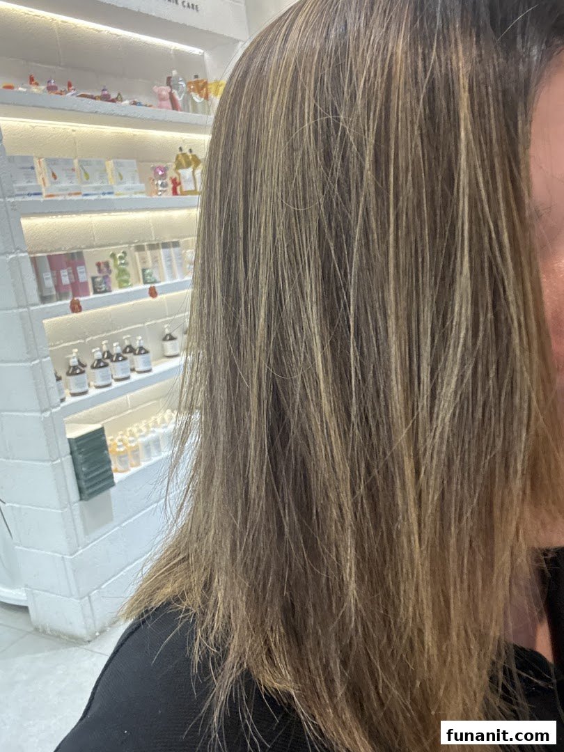 Close-up of a customer's hair, showcasing hair care products displayed on shelves in the background.
