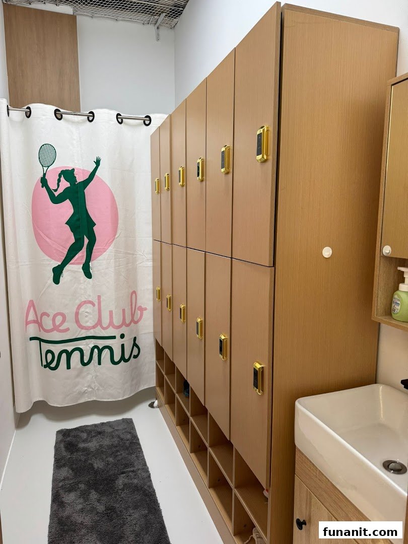 Interior view of Ace Club Tennis changing room with lockers, a themed curtain, and a sink.