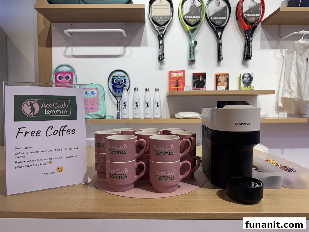 A complimentary coffee station with branded mugs and a 'Free Coffee' sign inside Ace Club Tennis.
