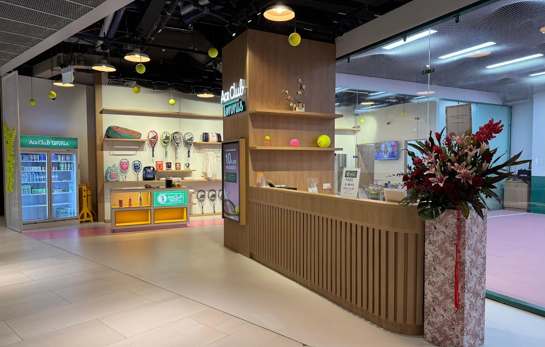Interior view of Ace Club Tennis, showcasing merchandise displays, a reception desk, and a tennis court.
