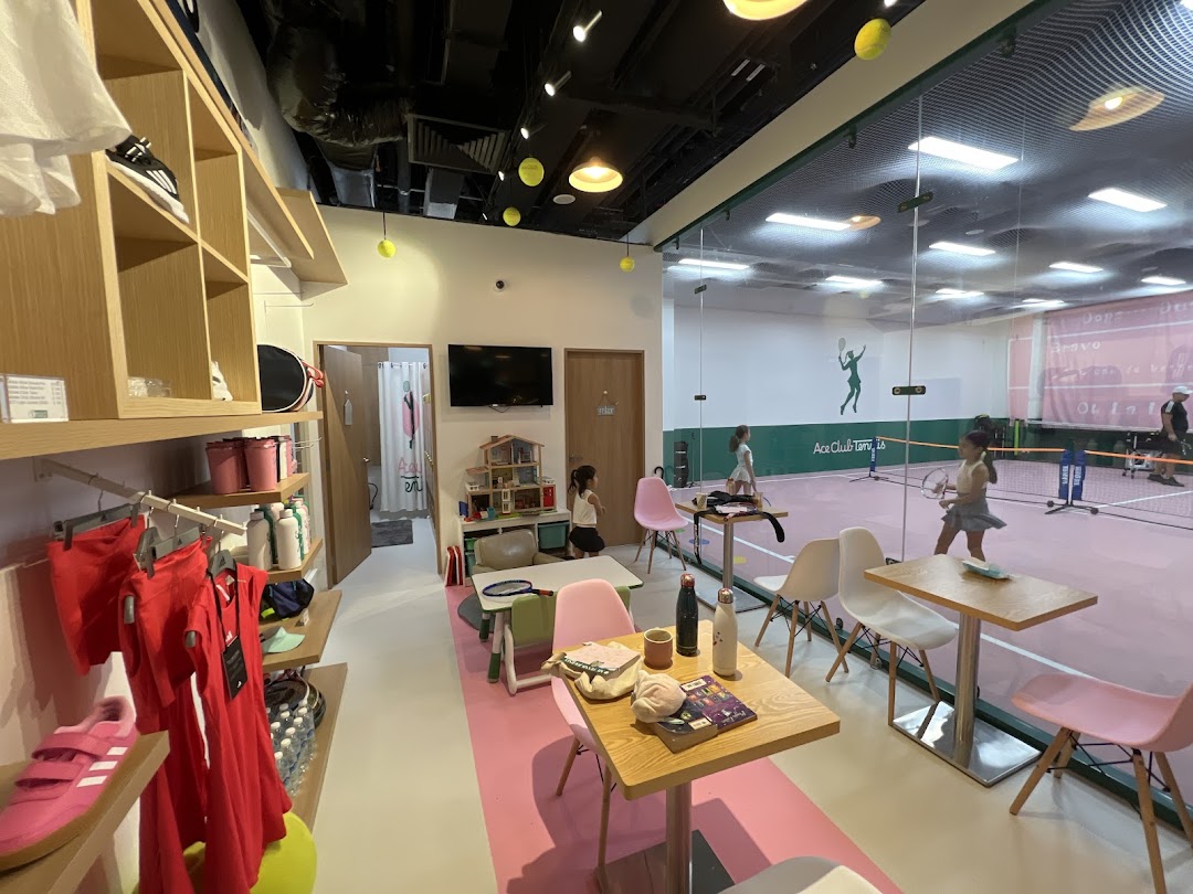 Interior view of Ace Club Tennis, showing a retail area and an indoor tennis court with players.