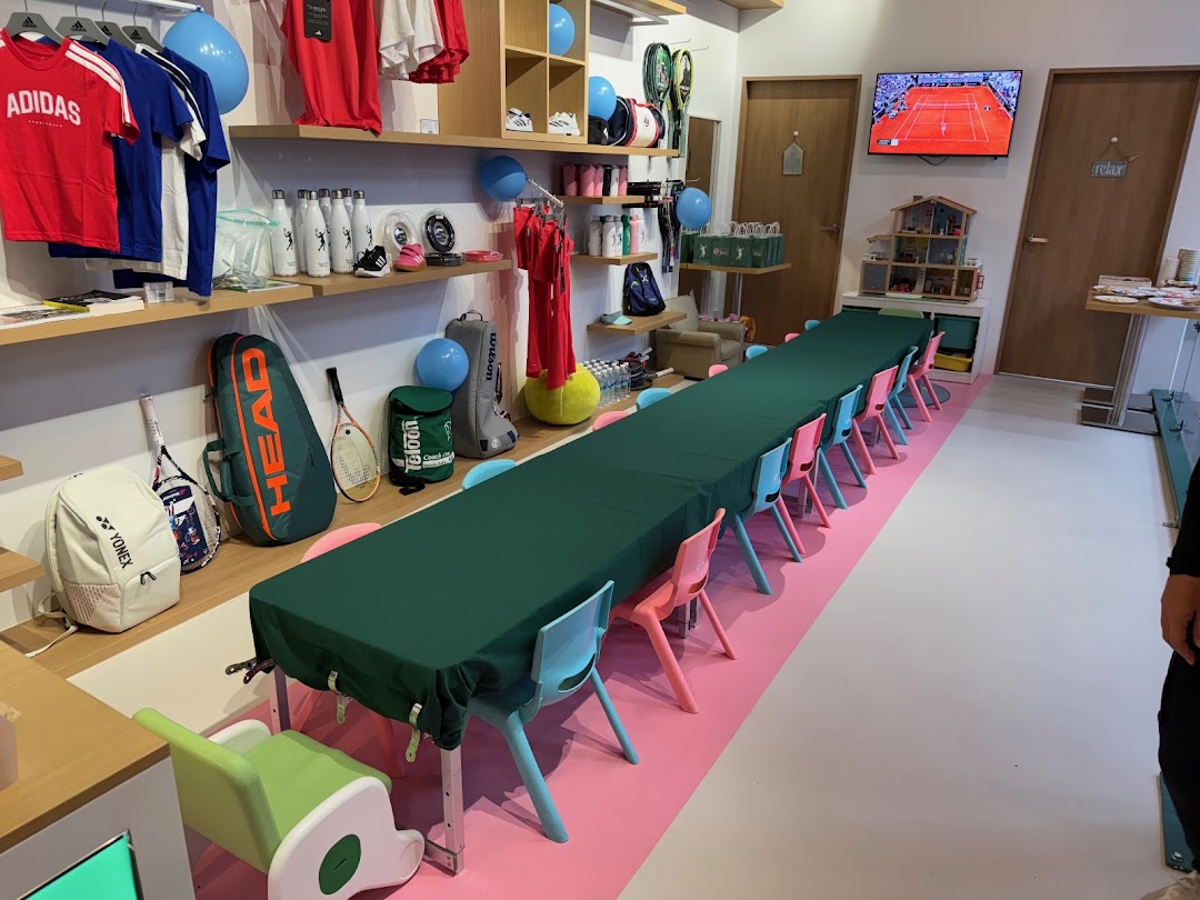 Interior view of Ace Club Tennis, featuring tennis gear, apparel, and a long table set up for activities.