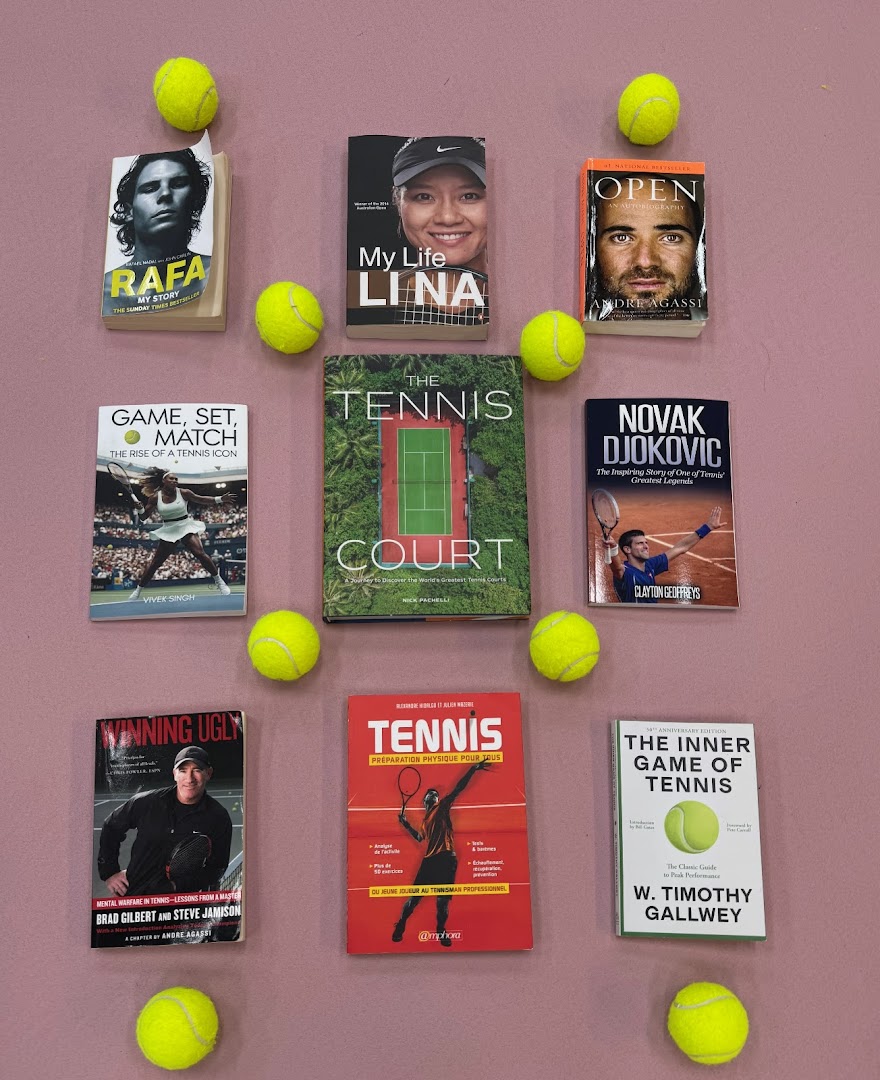 An overhead view of various tennis-themed books and bright yellow tennis balls arranged on a pink surface.